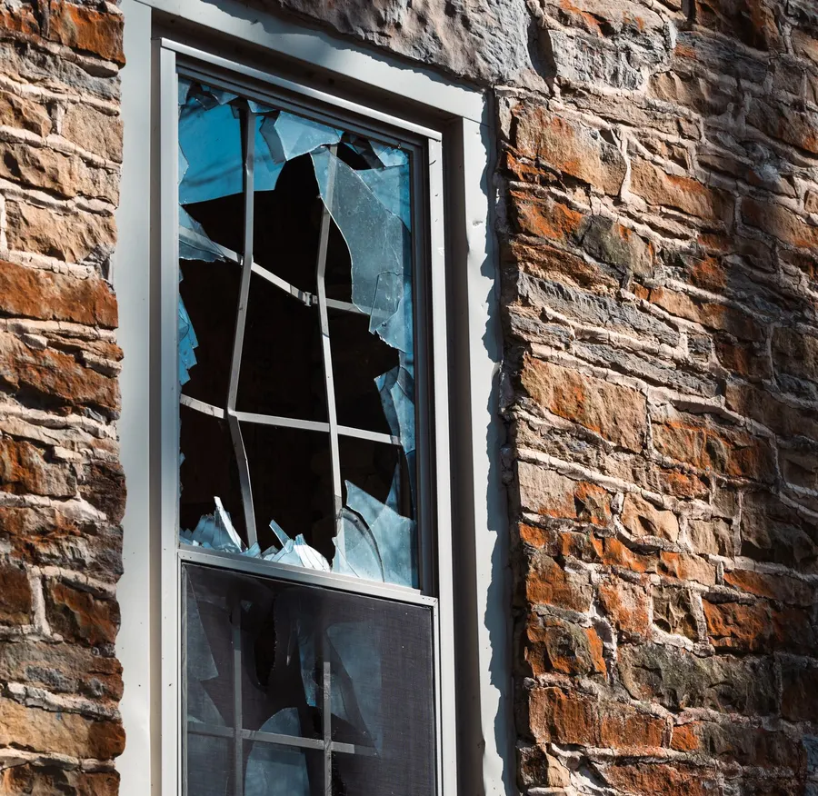 Broken window pane in a brick wall