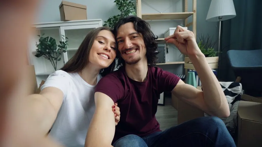 Couple holding up keys in their new home